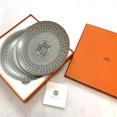 two plates and an orange box on a white surface