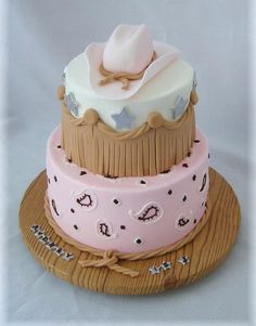 a three tiered cake decorated with pink and brown icing