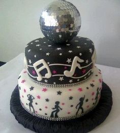 a three tiered cake decorated with music notes and disco balls