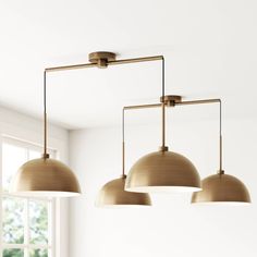 three light fixtures hanging from the ceiling in a room with white walls and flooring