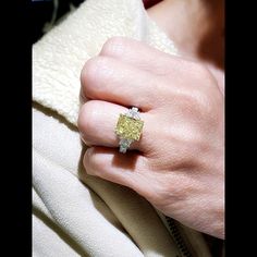 a woman's hand with a yellow and white diamond ring