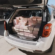 the back end of a white car filled with boxes