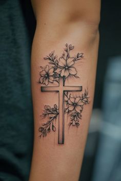 Cross tattoo adorned with flowers on forearm. Feminine Bible Verse Tattoos, Bible Verse Inspired Tattoo, Tattoos For Mentality, Small Tattoos For Moms With Sons, Faithful Tattoo Ideas, Wrist Rose Tattoos For Women, Tattoo Ideas Female Birds, Elegant Cross Tattoo, Faith Inspired Tattoos