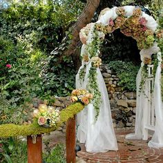 the wedding arch is decorated with flowers and greenery