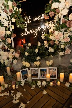 flowers and candles are arranged on the floor in front of a lighted sign that says it was always good