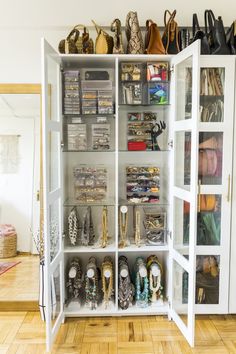 a white cabinet filled with lots of purses and shoes