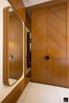 an empty bathroom with wooden cabinets and mirrors