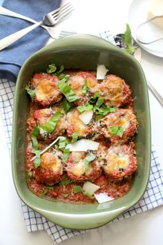 a green casserole dish filled with meatballs and parmesan cheese