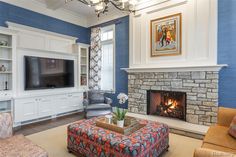 the living room is decorated in blue and white with a fire place on one side