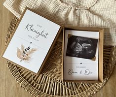 an open box containing a baby's handprint photo and the birth announcement card