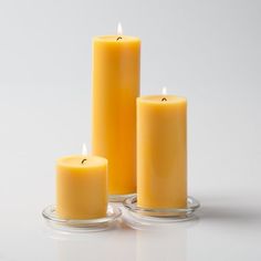 three yellow candles sitting on top of each other