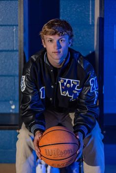 a young man holding a basketball in his hands