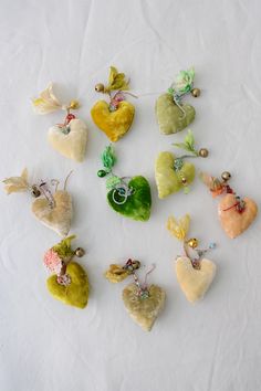 many different colored heart shaped ornaments on a white surface