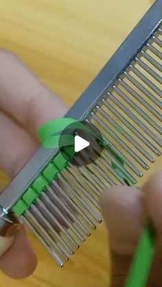 someone is holding a comb with green handles