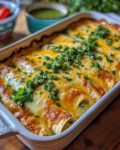 a casserole dish with cheese and herbs in it on a wooden table next to other dishes