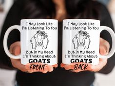 two white coffee mugs with goats on them, one says i may look like i'm listening to you and the other says i'm thinking about goats front