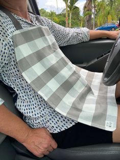 a man sitting in the driver's seat of a car with his hand on the steering wheel