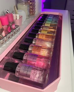 a pink vanity with lots of different types of nail polish