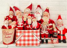 a group of santa clause figurines sitting on top of a table next to a bucket