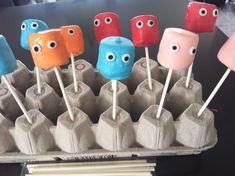 an egg carton filled with marshmallows and monster eyes on top of toothpicks