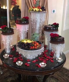 a table topped with three vases filled with flowers and greenery on top of it