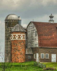 an old brick barn and silo on a cloudy day