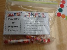 some candy wrapped in plastic on top of a wooden table next to a notepad