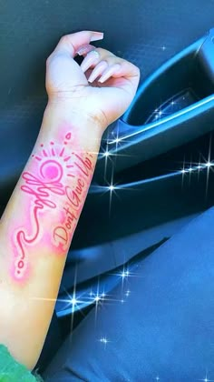 a woman's arm with a pink tattoo on it