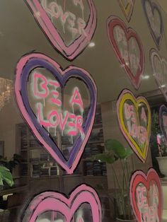 many hearts are painted on the glass in front of a store window with words written below them