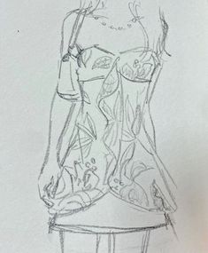 a drawing of a woman's dress on a white paper with a pencil in her hand