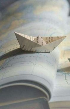 two paper boats floating on top of an open book