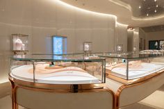 the inside of a jewelry store with glass shelves and gold trimmings on display