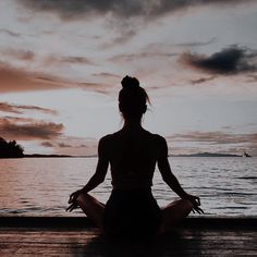 a woman sitting in the middle of a body of water