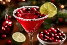 a red cocktail with cranberries and lime garnish