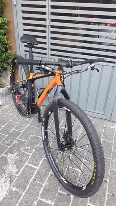 an orange and black bike parked in front of a building