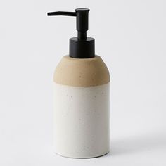 a white and black soap dispenser on a white background