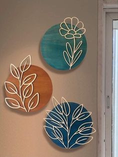 three metal wall hangings with flowers and leaves on them