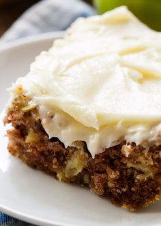 a close up of a piece of cake on a plate with cream cheese frosting