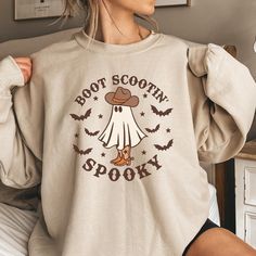 Boot Scootin' Spooky Sweatshirt, Halloween Shirts, Halloween Sweatshirt, Funny Halloween Shirt, Funny Coffee Shirts This boot scootin' spooky graphic is printed on 100% cotton Tees and Gildan 18000 crewneck sweatshirts. We use the best quality designs and printing techniques to give you a product you will absolutely love. We print with commercial DTG equipment and only use Oeko-Tex Eco Passport Certified Ink. Please see sizing images on the listing for size and measurements.  ORDERING 1 - Select Boot Scootin Spooky, Cowboy Ghost, Spooky Sweatshirt, Flower Boots, Western Halloween, Country Boots, Halloween Sweater, Ghost Shirt, Halloween Shirts