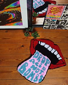 two knitted rugs with the words rock and roll on them next to an open book