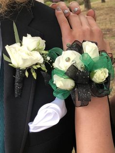 two brides holding each other's hands with white and green flowers on them