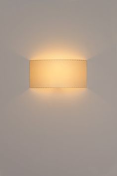 a square light fixture mounted on the wall in a room with white walls and flooring