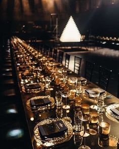 a long table is set up with candles and place settings for an elegant dinner party