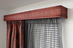 the curtain is hanging on the window sill in front of the window with red curtains