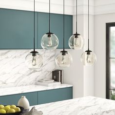 a kitchen with marble counter tops and hanging lights