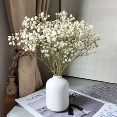 a vase filled with white flowers on top of a table