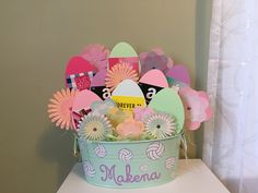 a basket filled with lots of different types of paper flowers and decorations on top of a table