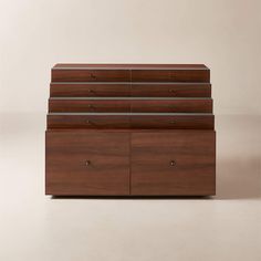 a wooden dresser with three drawers and two doors on the top, in front of a beige background