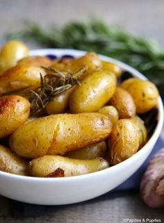 a white bowl filled with potatoes next to garlic