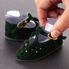 Tallina's Green Velvet Doll Shoes. Complete your doll's ensemble with this pair of must-have Tallina's Green Velvet Doll Shoes!    Every outfit needs the perfect pair of shoes. With these fashionable baby doll shoes, you can make sure your doll steps up their style for any occasion. Perfect for doll making, baby shower favors, and more.    What size shoes will fit my doll?  Just like people, dolls have different sized feet. Using a cloth measuring tape with millimeter increments, measure for the length of your doll's foot from heel to toe then measure the at the widest point for the width. You can also trace the doll's foot on a sheet of blank paper to measure the length and width. If measuring bare feet, add an additional 5 millimeters to the length to ensure a correct fit.    Size: 2 Baby Doll Furniture, Baby Doll Shoes, Velvet Dolls, Doll Shoe Patterns, Fashionable Baby, Sewing Doll Clothes, Shoes Socks, Shoe Pattern, Blank Paper